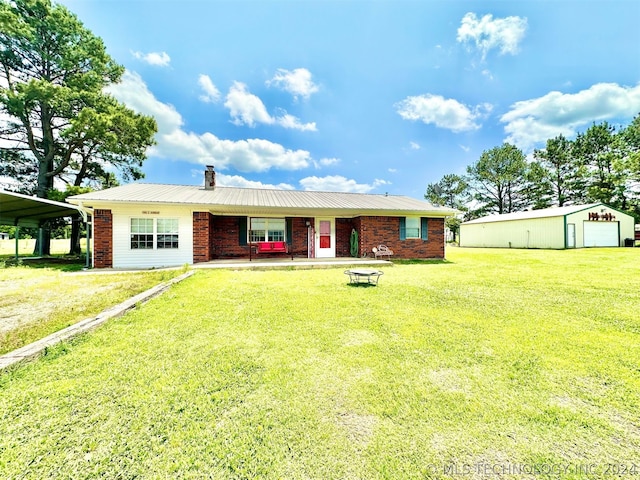 ranch-style house with a garage, a front lawn, a carport, and an outdoor structure