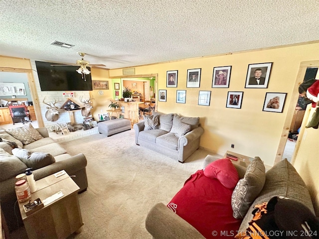 carpeted living room with ceiling fan and a textured ceiling