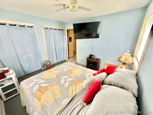 bedroom with carpet, ceiling fan, and a textured ceiling