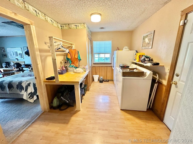 interior space featuring washing machine and dryer, light hardwood / wood-style floors, and a textured ceiling