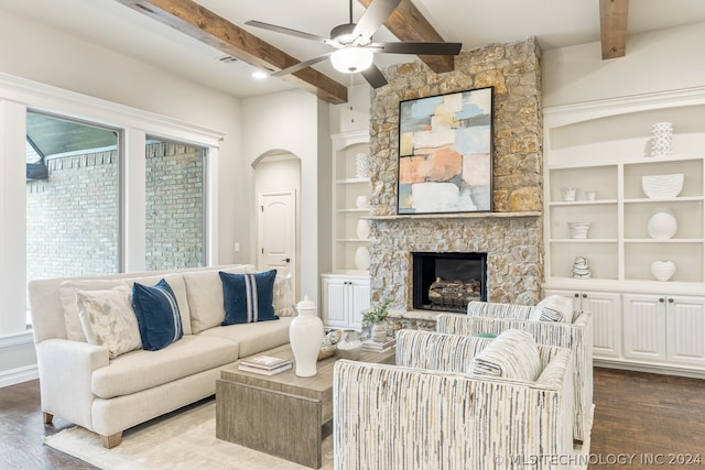 living room featuring a fireplace, beamed ceiling, built in shelves, wood-type flooring, and ceiling fan