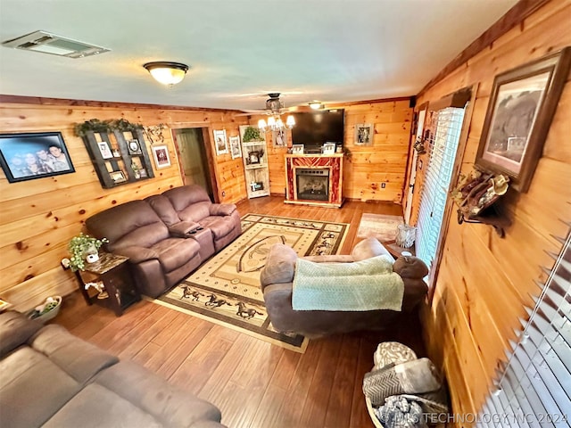 living room featuring wooden walls, ceiling fan, and hardwood / wood-style floors