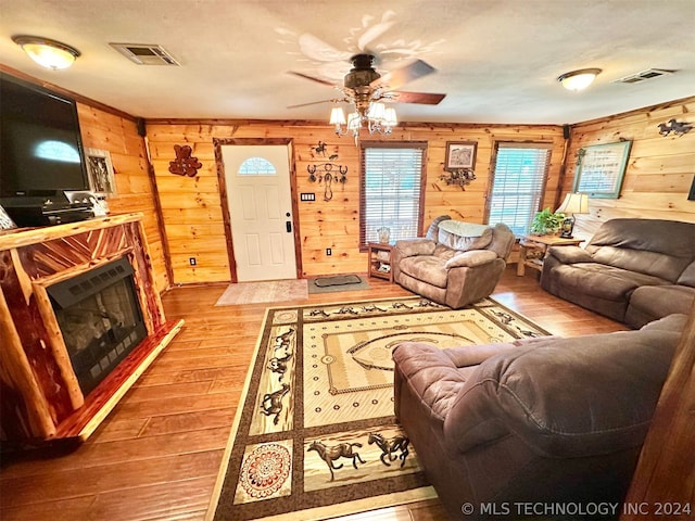 living room with wooden walls, ceiling fan, and hardwood / wood-style flooring