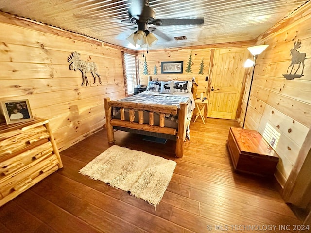 bedroom with wooden walls, ceiling fan, and hardwood / wood-style floors