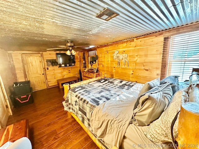 bedroom featuring dark hardwood / wood-style floors, ceiling fan, and wood walls