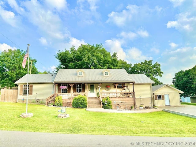 ranch-style home featuring a front yard, an outdoor structure, and a porch