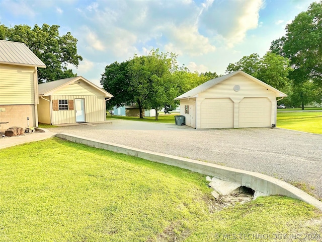 view of front of home with an outdoor structure, a front lawn, and a garage