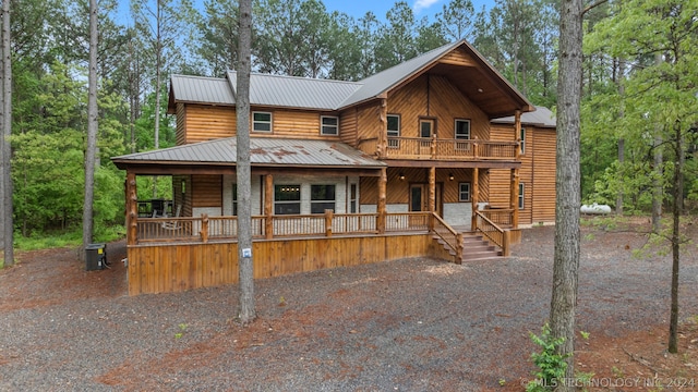 log-style house featuring a balcony and covered porch