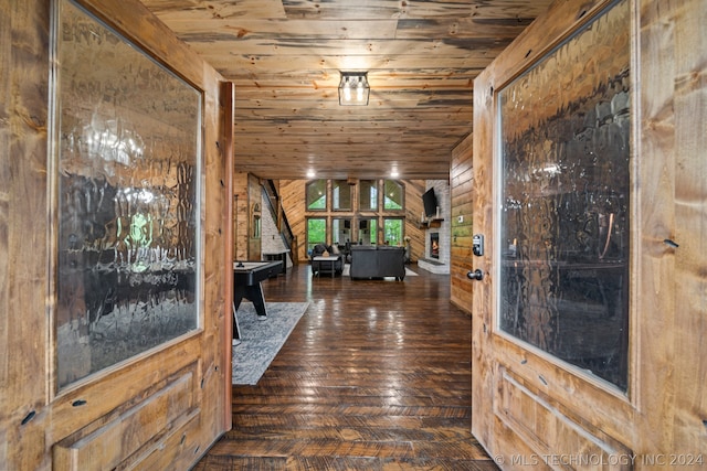 foyer with dark hardwood / wood-style floors, wood ceiling, and wood walls