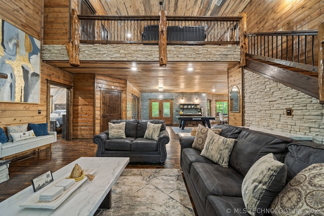 living room featuring a towering ceiling and wood walls