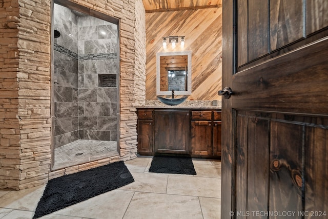 bathroom with a shower, tile flooring, vanity, wood walls, and wooden ceiling