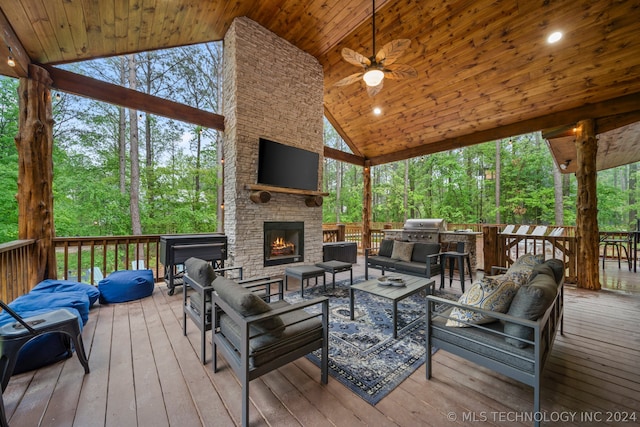 wooden terrace featuring a grill, an outdoor living space with a fireplace, and ceiling fan