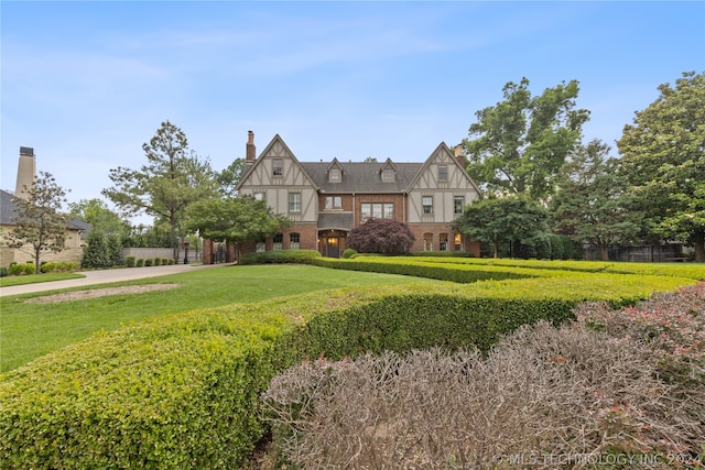 tudor home with a front lawn