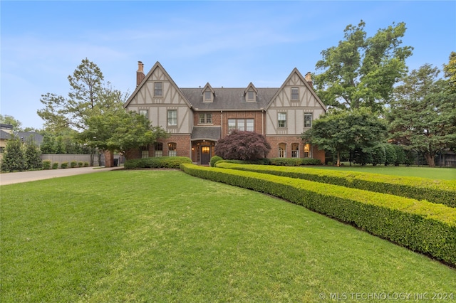 tudor-style house with a front lawn