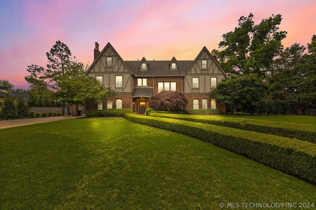 english style home with a lawn