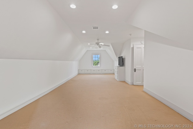 additional living space with ceiling fan, vaulted ceiling, and light colored carpet