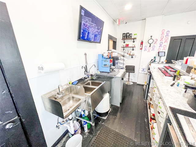 miscellaneous room with sink, dark hardwood / wood-style floors, and a drop ceiling