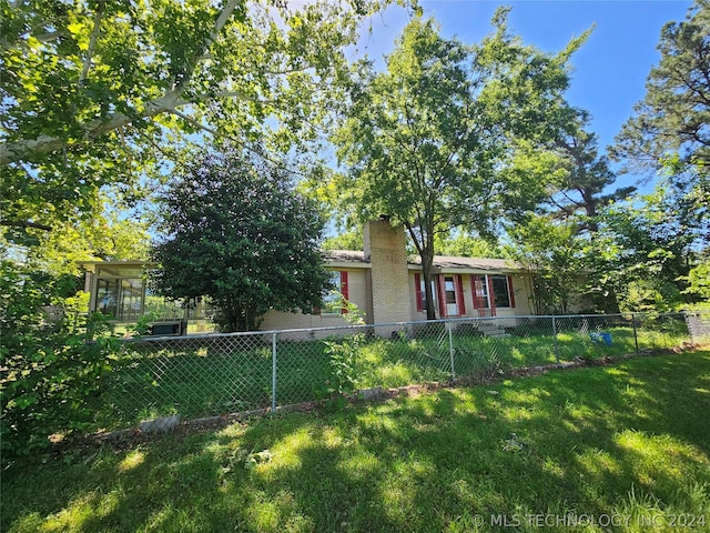 view of front of home with a front lawn and a sunroom