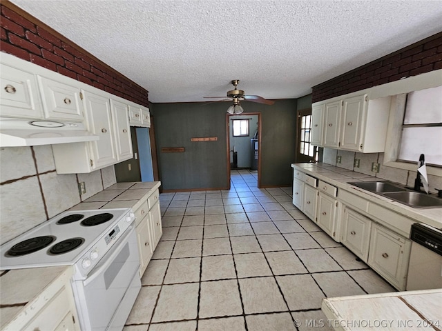 kitchen featuring sink, white appliances, white cabinetry, and brick wall