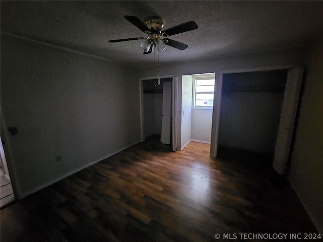 unfurnished bedroom featuring a textured ceiling, ceiling fan, and dark hardwood / wood-style floors