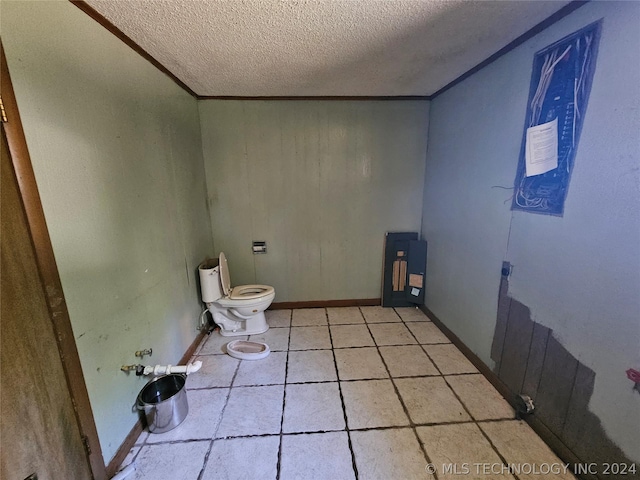 bathroom featuring tile patterned floors, a textured ceiling, toilet, and ornamental molding