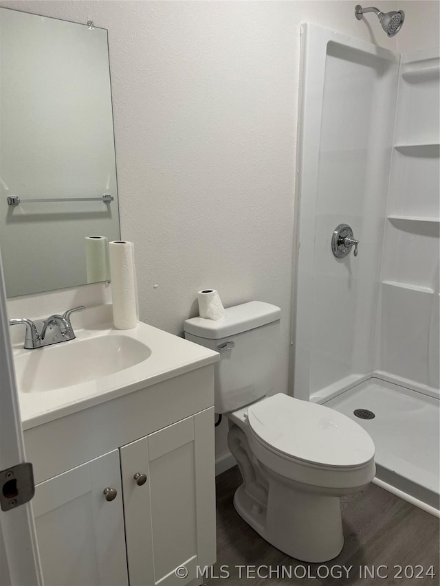 bathroom with vanity, hardwood / wood-style flooring, toilet, and walk in shower