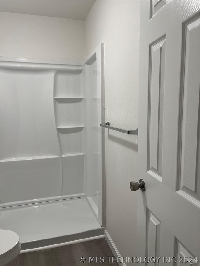 bathroom with a shower and hardwood / wood-style flooring