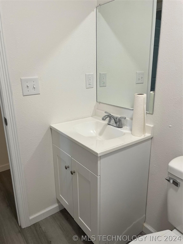 bathroom with vanity, toilet, and wood-type flooring