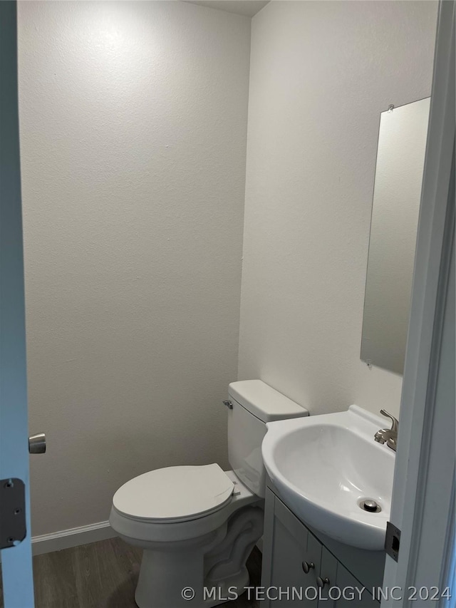 bathroom with vanity, hardwood / wood-style flooring, and toilet