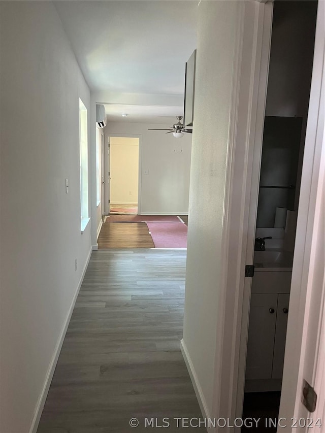 corridor featuring hardwood / wood-style floors, sink, and a wall mounted AC