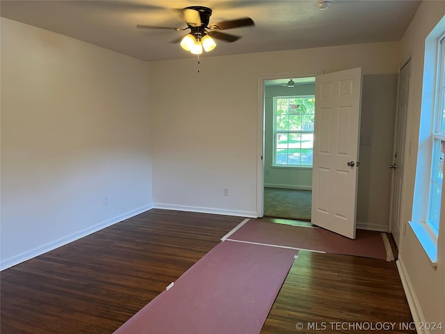 empty room with ceiling fan and dark hardwood / wood-style flooring