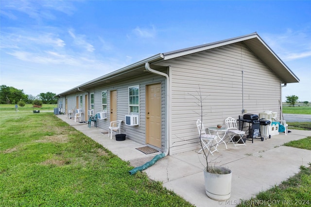 view of side of property featuring cooling unit, a yard, and a patio