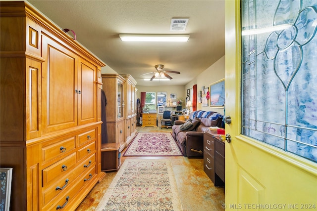 interior space featuring ceiling fan and a textured ceiling