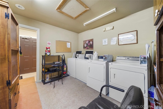 laundry room with washing machine and clothes dryer and light colored carpet