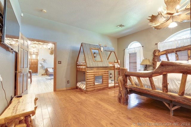 bedroom with light hardwood / wood-style floors and a textured ceiling