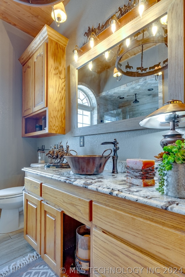 bathroom featuring dual bowl vanity, toilet, and tile floors