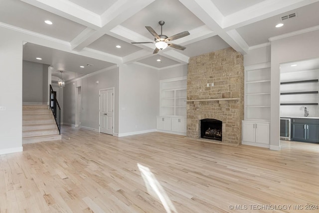 unfurnished living room with beam ceiling, light hardwood / wood-style flooring, and coffered ceiling