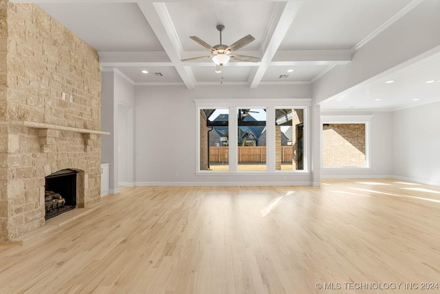 unfurnished living room featuring a fireplace, ornamental molding, coffered ceiling, light hardwood / wood-style flooring, and beamed ceiling