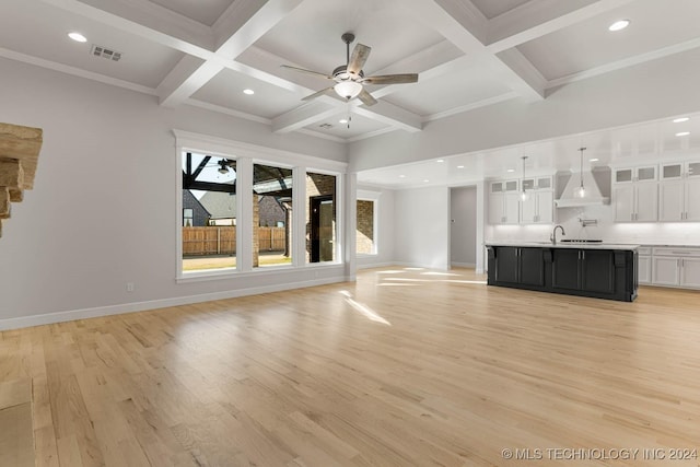 unfurnished living room featuring coffered ceiling, ceiling fan, crown molding, light hardwood / wood-style flooring, and beamed ceiling