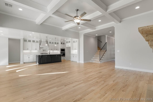 unfurnished living room with beamed ceiling, light hardwood / wood-style floors, and coffered ceiling