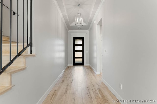 foyer entrance featuring crown molding, light hardwood / wood-style flooring, and a chandelier