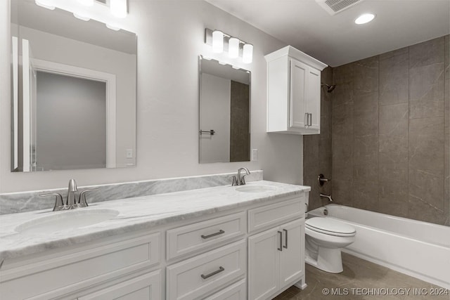 full bathroom featuring tiled shower / bath combo, toilet, and vanity