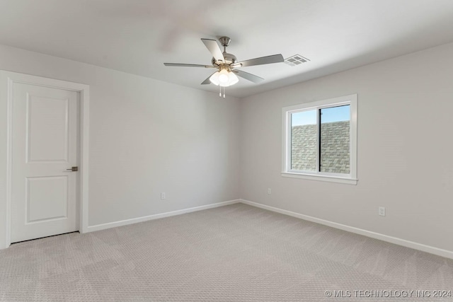 carpeted spare room featuring ceiling fan