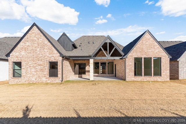 rear view of house featuring a lawn and a patio area