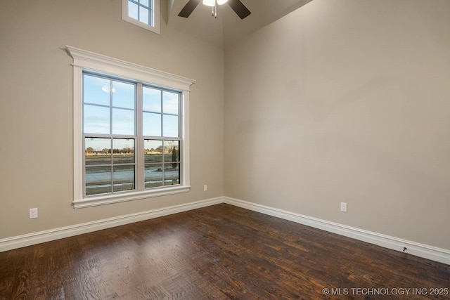 spare room featuring ceiling fan, dark wood-type flooring, and vaulted ceiling