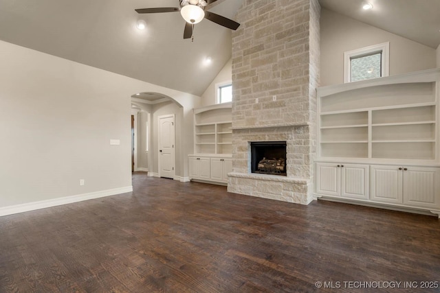 unfurnished living room featuring ceiling fan, dark hardwood / wood-style flooring, high vaulted ceiling, built in features, and a fireplace