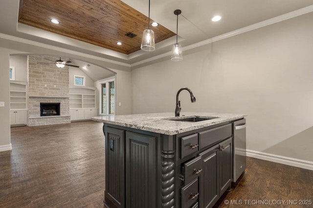 kitchen featuring ceiling fan, sink, pendant lighting, a center island with sink, and wooden ceiling