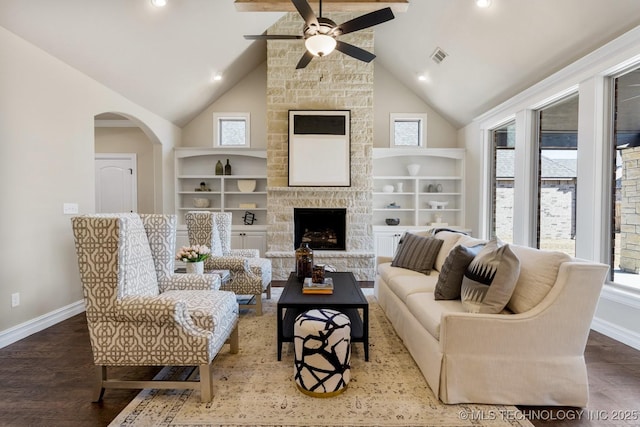 living area featuring built in shelves, a wealth of natural light, baseboards, and wood finished floors