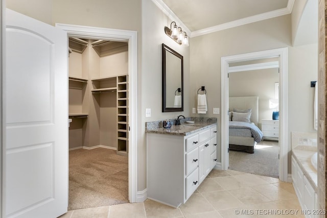 full bathroom with ensuite bath, ornamental molding, a spacious closet, vanity, and tiled tub