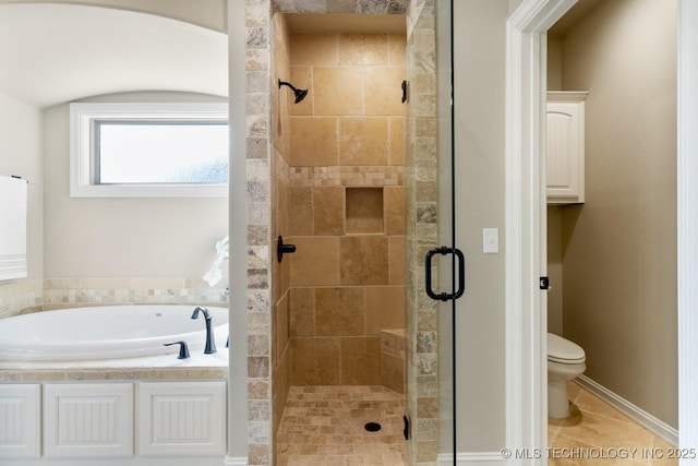 bathroom with a stall shower, tile patterned flooring, a garden tub, and toilet